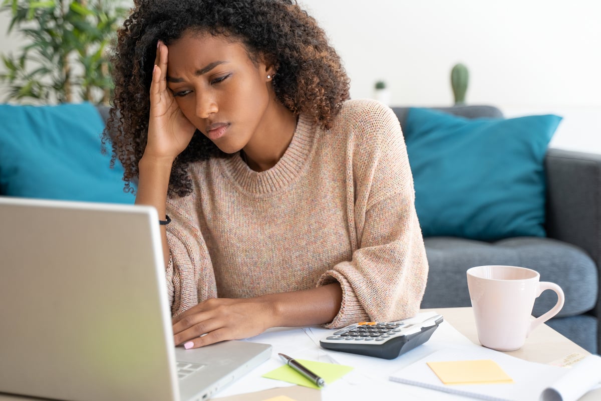 Stressed black woman working at home alone